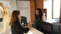 A patient checking in at the front desk to the Mothers Center